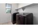 Laundry room with modern machines, a window providing natural light, and a convenient storage shelf at 4744 E Tierra Buena Ln, Phoenix, AZ 85032