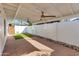 This covered back patio features brick flooring, turf, privacy walls, and ceiling fans at 5333 N Las Casitas Pl, Phoenix, AZ 85016