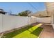 This back patio features brick flooring, turf, a privacy wall, and a covered patio area at 5333 N Las Casitas Pl, Phoenix, AZ 85016
