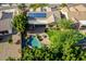 Aerial view of a house with a backyard pool, firepit, lush landscaping, and solar panels at 5523 W Yearling Rd, Phoenix, AZ 85083