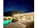 Backyard with a firepit, a pool, outdoor kitchen, and covered seating area at dusk at 5523 W Yearling Rd, Phoenix, AZ 85083