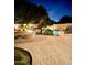 Backyard with a firepit, a pool, and lush landscaping at night at 5523 W Yearling Rd, Phoenix, AZ 85083
