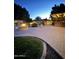 Backyard with a firepit, a pool, an outdoor kitchen and lush landscaping at dusk at 5523 W Yearling Rd, Phoenix, AZ 85083