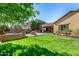 Expansive backyard featuring a well-manicured lawn, fire pit, and covered patio area at 5523 W Yearling Rd, Phoenix, AZ 85083