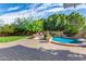 Beautiful backyard with a pool, lush lawn, and paved patio area at 5523 W Yearling Rd, Phoenix, AZ 85083