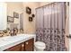 Charming bathroom featuring a vanity with modern fixtures and a shower with floral curtain at 5523 W Yearling Rd, Phoenix, AZ 85083