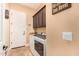 Functional laundry room featuring modern appliances, upper cabinets, and access to the garage at 5523 W Yearling Rd, Phoenix, AZ 85083