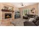Comfortable living room with a cozy fireplace, plush seating, and natural light at 5523 W Yearling Rd, Phoenix, AZ 85083
