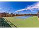 Well-maintained tennis court with net, surrounded by fencing and desert landscape, offering a scenic and private playing environment at 5523 W Yearling Rd, Phoenix, AZ 85083