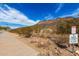 Scenic walking path with desert landscaping, mountain views, and signage, promoting responsible pet ownership and conservation at 5523 W Yearling Rd, Phoenix, AZ 85083