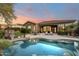 Relaxing backyard with a sparkling pool, covered patio, and lush landscaping; perfect for entertaining or unwinding at 5892 E Evening Glow Dr, Scottsdale, AZ 85266