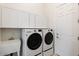 Well-lit laundry room with modern washer and dryer, storage cabinets, and utility sink at 5892 E Evening Glow Dr, Scottsdale, AZ 85266