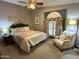 Cozy bedroom featuring a ceiling fan, accent chair, and a large window at 6161 S Pinehurst Dr, Chandler, AZ 85249