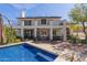 Beautiful backyard view of a two-story home with a sparkling pool and patio area at 6576 W Lone Cactus Dr, Glendale, AZ 85308