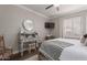 This bedroom features a ceiling fan, shuttered windows, and an antique-style desk at 6576 W Lone Cactus Dr, Glendale, AZ 85308