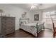 Inviting bedroom showcasing a soft bed, wooden dresser, and abundant natural light at 6576 W Lone Cactus Dr, Glendale, AZ 85308