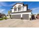 Home exterior featuring a three-car garage, desert landscaping, and a tile roof at 6576 W Lone Cactus Dr, Glendale, AZ 85308