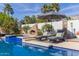 Sparkling pool with lounge chairs, sun umbrella, and outdoor fireplace, perfect for relaxation at 6576 W Lone Cactus Dr, Glendale, AZ 85308