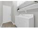 Well-lit laundry room with modern washer, dryer, white cabinets, shelving, and an exterior door at 7006 E Jensen St # 33, Mesa, AZ 85207