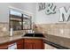 Kitchen sink features granite countertops, stylish backsplash, and a bright window view at 751 W Elgin St, Chandler, AZ 85225