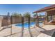 Fenced pool area with a blue pool, a lounge chair, and a gray umbrella at 751 W Elgin St, Chandler, AZ 85225