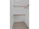 A bright walk-in closet with wooden clothing rods and modern gray wood-style flooring at 7538 E Forge Ave, Mesa, AZ 85208
