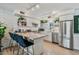 Bright kitchen with white cabinets, stainless steel appliances, and open shelving adorned with plants at 7601 E 2Nd St # 20, Scottsdale, AZ 85251