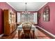 Dining room featuring hardwood floors, decorative chandelier, and large window with plantation shutters at 802 N Butte Ave, Chandler, AZ 85226