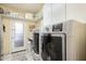 Laundry room with washer, dryer, storage shelving, and convenient access to outdoor space at 802 N Butte Ave, Chandler, AZ 85226