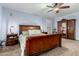 Comfortable main bedroom featuring carpet, ceiling fan, and a matching armoire at 802 N Butte Ave, Chandler, AZ 85226