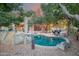 Beautiful backyard pool surrounded by lush greenery, rocks, and ambient string lighting creating a tranquil oasis at 802 N Butte Ave, Chandler, AZ 85226