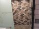 Tiled shower stall with glass door and modern showerhead at 8219 N 59Th Ave, Glendale, AZ 85302