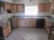 Bright kitchen features ample cabinet space, stainless steel sink, dishwasher, and tile flooring at 8219 N 59Th Ave, Glendale, AZ 85302