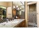 Bathroom featuring granite counters, custom cabinetry, and a walk-in shower with checkered tile at 8306 N Merion Way, Paradise Valley, AZ 85253