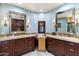 A lavish bathroom featuring dual vanities, marble countertops and framed mirrors at 8306 N Merion Way, Paradise Valley, AZ 85253
