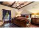 Comfortable bedroom with wood ceiling, terracotta floors, and an exterior door to the backyard at 8306 N Merion Way, Paradise Valley, AZ 85253