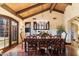 Elegant dining room with a wooden table, ornate chairs, chandelier, wood flooring, and exposed wood beam ceiling at 8306 N Merion Way, Paradise Valley, AZ 85253