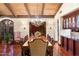 Elegant dining room with hardwood floors, stone accent wall, chandelier, and decorative wood beam ceiling at 8306 N Merion Way, Paradise Valley, AZ 85253