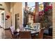 Charming dining area with a round wood table, leather chairs, chandelier, and large windows with a garden view at 8306 N Merion Way, Paradise Valley, AZ 85253