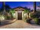 Elegant courtyard entrance with brick paving, mature palms and an ornate front door at 8306 N Merion Way, Paradise Valley, AZ 85253