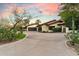 Exterior view of a home featuring a circular driveway and mature landscaping at 8306 N Merion Way, Paradise Valley, AZ 85253