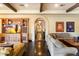 Comfortable living room with beamed ceiling, built-in shelving, entertainment center, and an arched hallway entrance at 8306 N Merion Way, Paradise Valley, AZ 85253