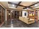 Comfortable living room featuring a beamed ceiling, entertainment center, and seamless flow to outdoor patio through glass doors at 8306 N Merion Way, Paradise Valley, AZ 85253