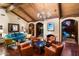 Inviting living room features a fireplace, wood-beamed ceiling, hardwood floors, and comfortable seating arrangement at 8306 N Merion Way, Paradise Valley, AZ 85253