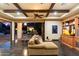 Inviting living room with beamed ceiling, comfortable sofa, entertainment center, and seamless transition to outdoor patio at 8306 N Merion Way, Paradise Valley, AZ 85253