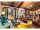Bright living room offers a stone fireplace, cathedral beamed ceiling, wooden floors, and comfortable seating at 8306 N Merion Way, Paradise Valley, AZ 85253