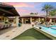 Expansive outdoor kitchen and dining area with built-in grill, bar seating, and putting green at 8306 N Merion Way, Paradise Valley, AZ 85253