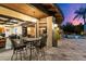 Covered outdoor patio with dining table, ceiling fan, and open views of the lush backyard and pool at 8306 N Merion Way, Paradise Valley, AZ 85253