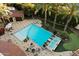 Aerial view of a backyard pool with lounge chairs, a fire pit, mature trees, and manicured landscaping at 8306 N Merion Way, Paradise Valley, AZ 85253