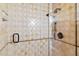 Close-up of a tiled shower featuring neutral earth-toned tiles, glass enclosure and a modern shower head at 8306 N Merion Way, Paradise Valley, AZ 85253